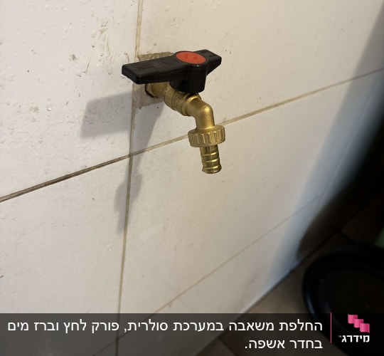 ברז מתכת עם ידית שחורה על קיר אריחים